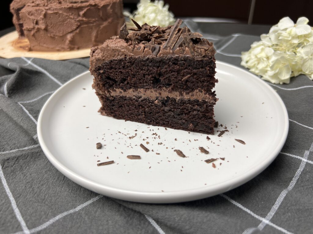 a slice of rich and moist chocolate cake on plate