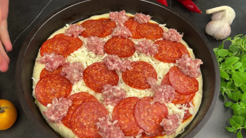 Homemade Pepperoni Sausage Pizza adding sauce the cheese pepperoni and sausage